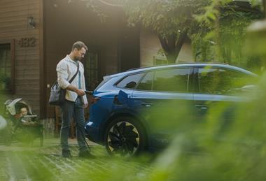 Business man charging EV with ba