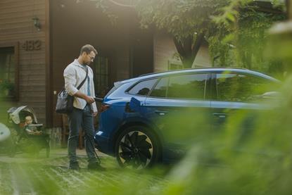 Business man charging EV with ba