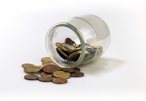 Jar of coins isolated on white, lying on a floor.