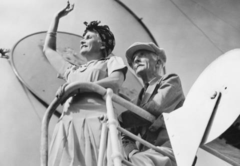 Couple standing at railing on cruiser deck (B&W), (low angle view)