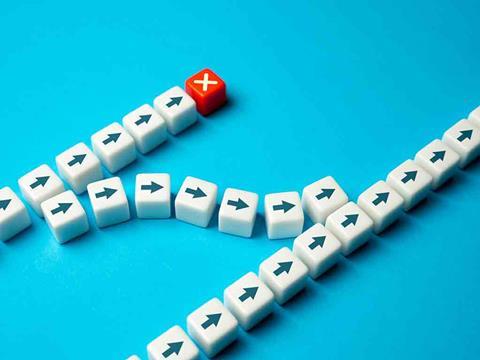 white dice with arrows facing one direction and a red dice with a cross on it