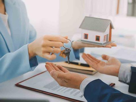 estate agent with a house model and keys