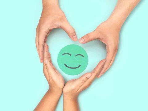 smiley face in hands making heart shape